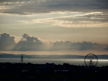 Silhouette ferris wheel against sky at sunset