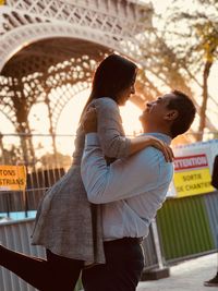 Side view of couple kissing on bridge