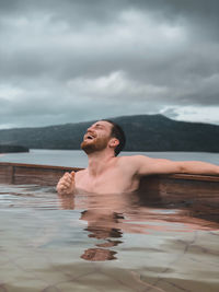 Portrait of shirtless man swimming in pool