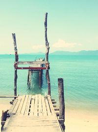 Wooden pier on sea against sky