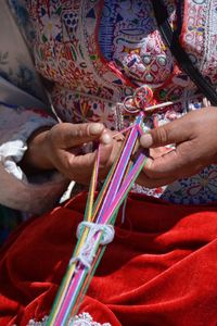 Midsection of men making artwork with thread