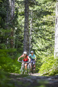 Two female bikers enjoy a trail in sandy, or near mt. hood.