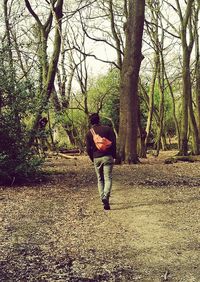 Full length of man with arms raised against trees
