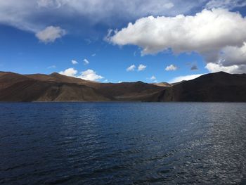 Scenic view of lake by mountains against sky