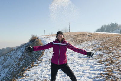 Woman standing on snow covered field