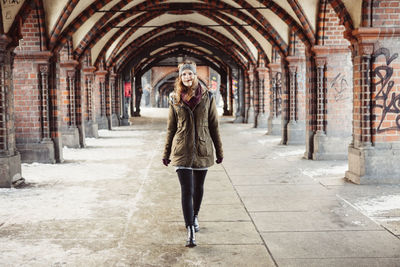 Portrait of beautiful young woman walking at railroad station platform