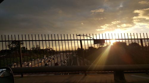 Bridge in city against sky during sunset