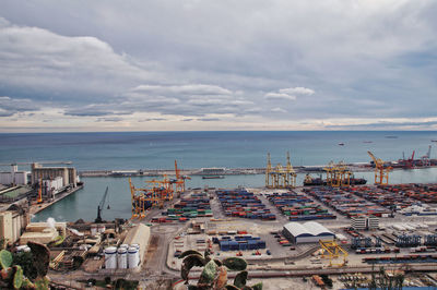 High angle view of commercial dock against cloudy sky, barcelona 