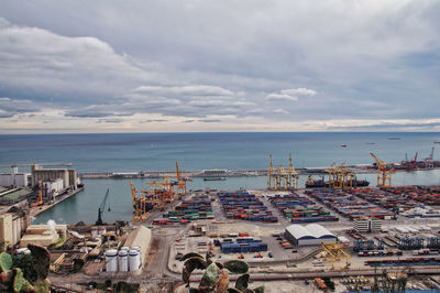 High angle view of commercial dock against cloudy sky, barcelona 