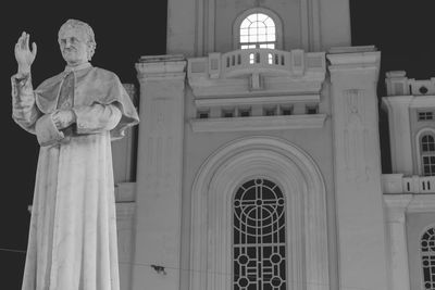 Statue against church at night