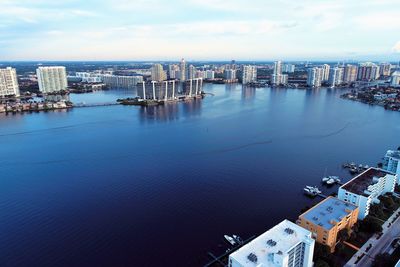 High angle view of city by sea against sky