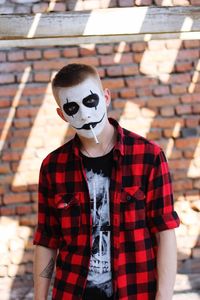 Portrait of young man standing against wall