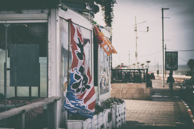 Multi colored flags hanging on street amidst buildings in city