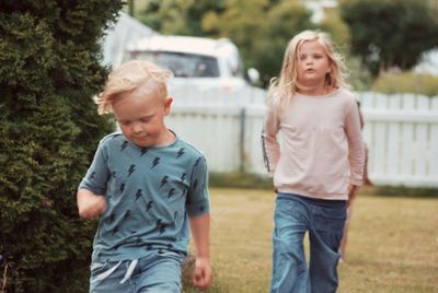 Siblings walking in yard