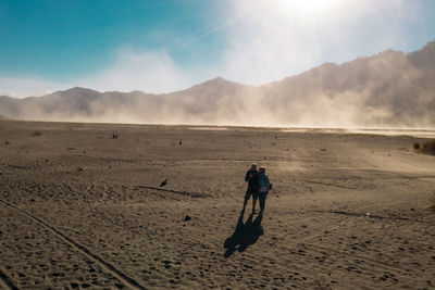 Man walking on desert against sky