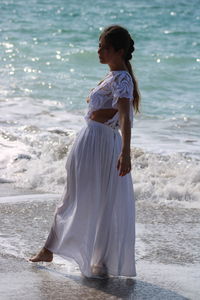 Rear view of woman standing on beach