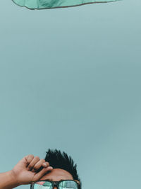 Low angle view of man wearing sunglasses against clear sky