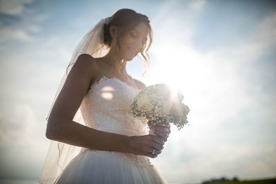 Low angle view of woman standing against sky