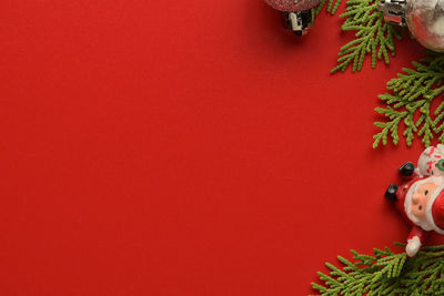 Close-up of christmas tree against red wall