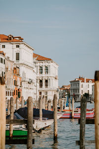 Wooden posts and boats on grand canal in city