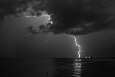 Lightning over sea against storm clouds
