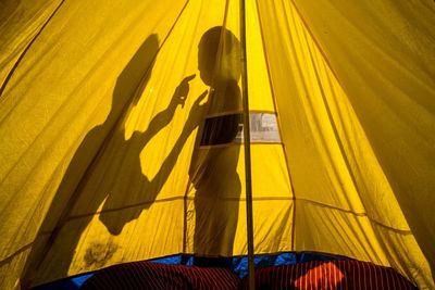 Low angle view of woman standing on yellow umbrella