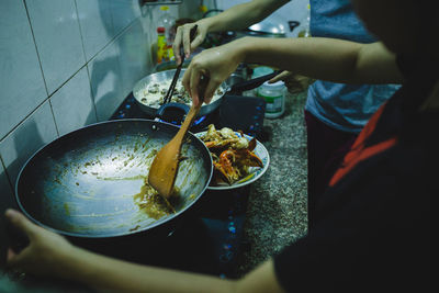 Midsection of women preparing food in kitchen