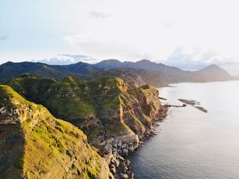 Scenic view of sea and mountains against sky