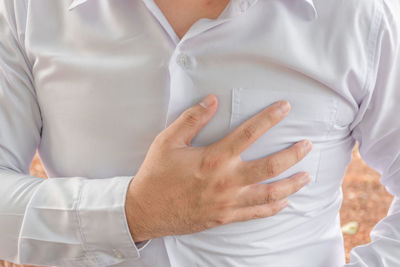 Midsection of man standing on bed