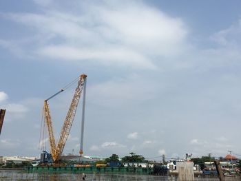 Cranes at construction site against sky