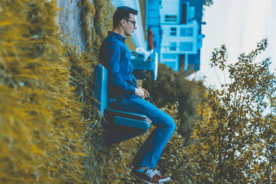 Tilt image of man sitting on bench