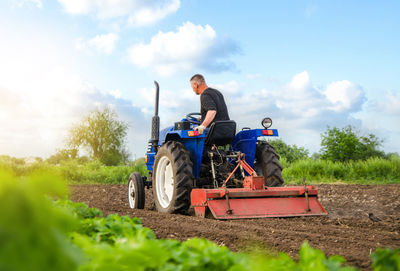 A farmer on a tractor works in the field. milling soil, crushing and loosening ground.