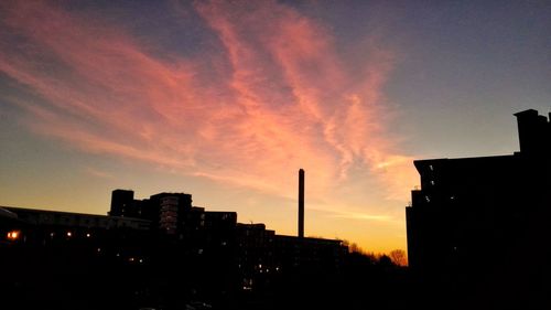 Silhouette city against sky during sunset