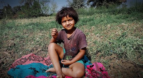 Full length of woman sitting on field