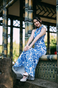 Portrait of young woman sitting on bench