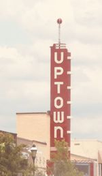 Information sign by building against sky