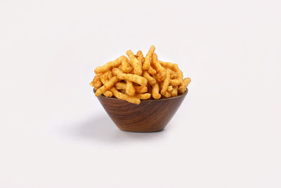 Close-up of fries on plate against white background