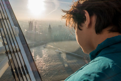 Portrait of boy looking through window