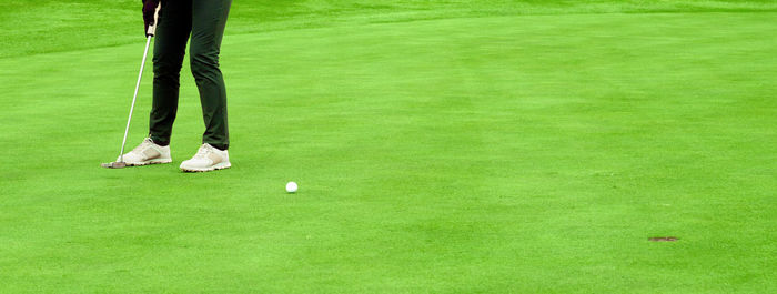 Low section of woman standing on golf ball