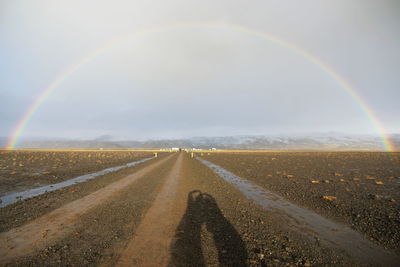 Scenic view of rainbow over road against sky