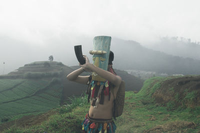 Man standing on field against sky