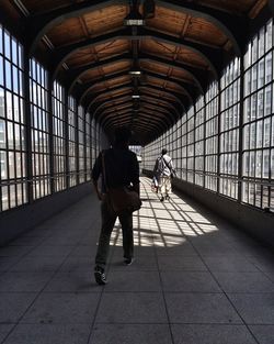 Rear view of man walking in corridor