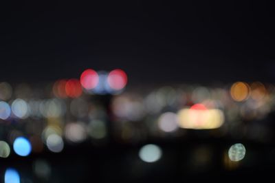 Defocused image of illuminated lights in city at night