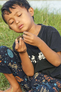 Portrait of young boy sitting on grass