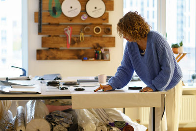 Side view of woman working at table