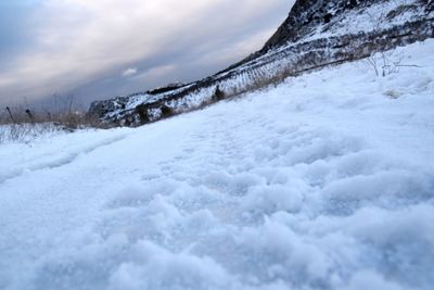 Snow covered landscape against sky