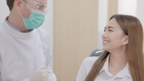 Portrait of smiling young woman looking at clinic