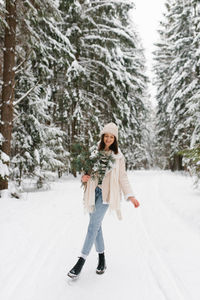 Caucasian woman is walking in snow with bouquet of flowers