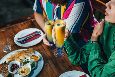 Midsection of people having food at table