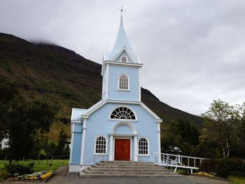 Church by building against sky